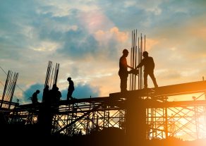 Silhouette of engineer and construction team working at site over blurred background sunset pastel for industry background with Light fair.