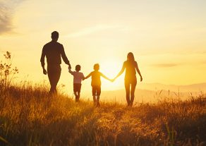 A family walking hand in hand at sunset, showcasing love and togetherness in nature.